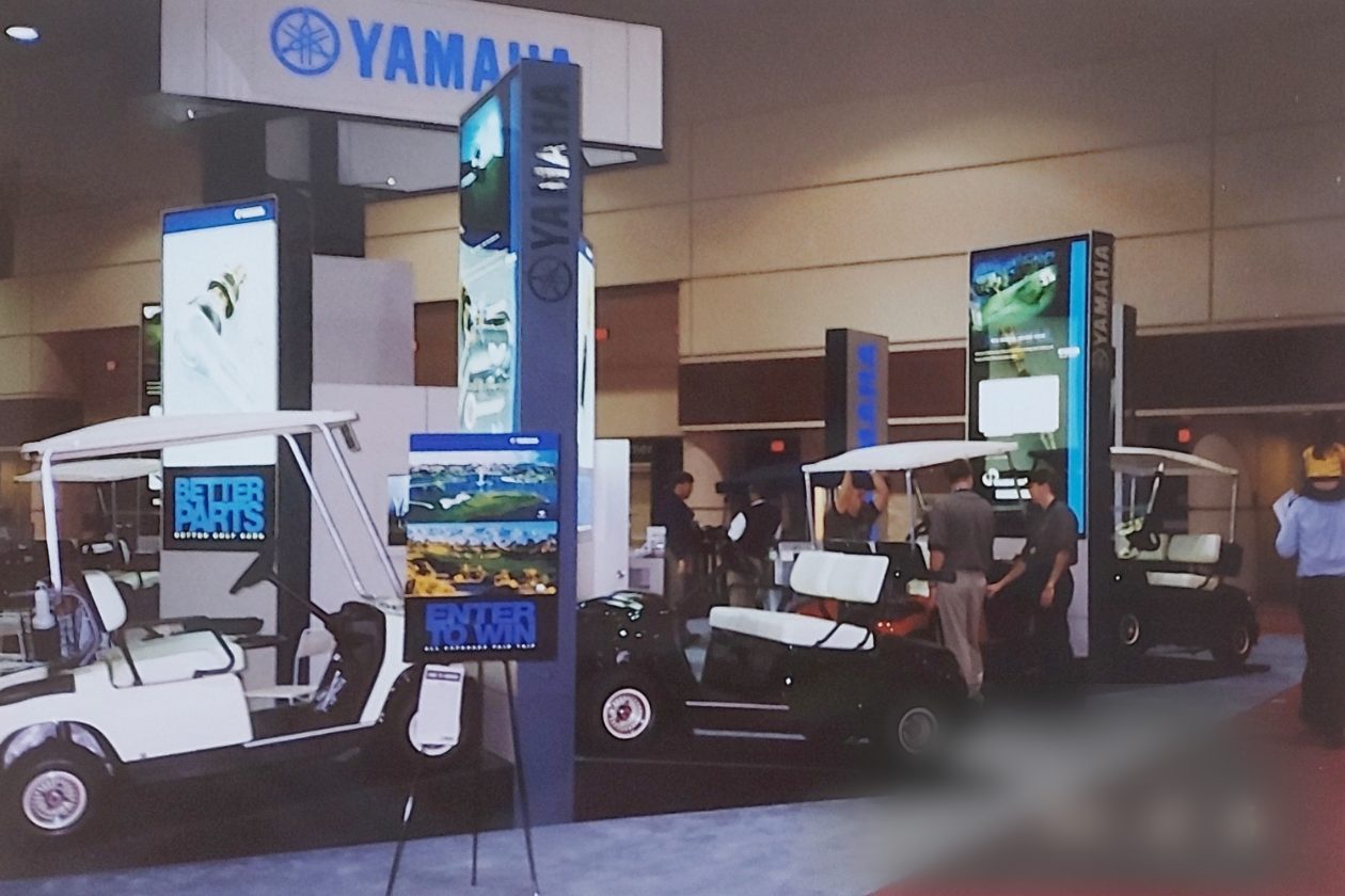 Stand de Yamaha Golf Car con carros en exposición, 2000